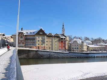 Winterurlaub in Bayern im BERGEBLICK Winterlicher Blick auf bunte Häuser und einen Fluss in einer kleinen Stadt