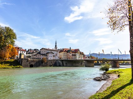 Sehenswert: Bad Tölz Fluss mit Brücke und historischer Stadt im Herbst bei sonnigem Wetter