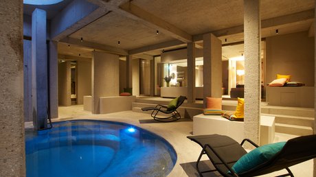Pictures of a dream holiday in Bad Tölz Heated indoor pool with modern lounge chairs and cushions in a spa area