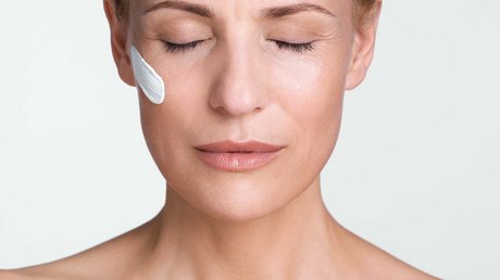 Pictures of a dream holiday in Bad Tölz Woman with closed eyes, face cream on cheek, praying with hands together