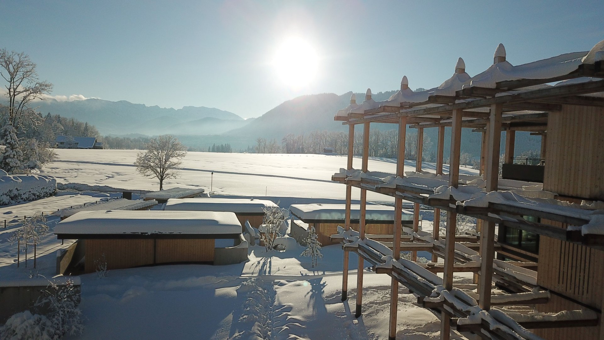 Hotel BERGEBLICK in Bavaria Snow-covered houses and trees at sunrise in a snowy landscape