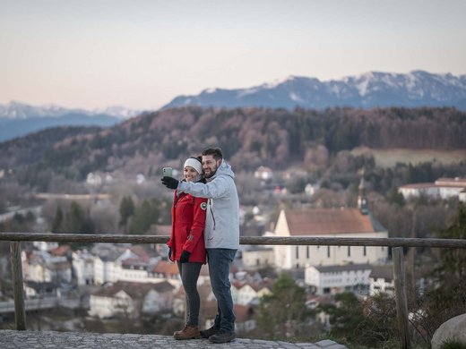 Your active holiday in Bavaria in Bad Tölz Couple taking a selfie with mountains and town in the background
