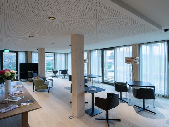 Wissenswertes aus Bad Tölz Moderner Aufenthaltsraum mit Tischen, Stühlen und Panoramafenstern