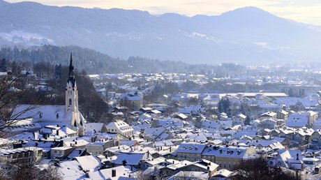 Pictures of a dream holiday in Bad Tölz Snow-covered town with church and forested mountains in winter