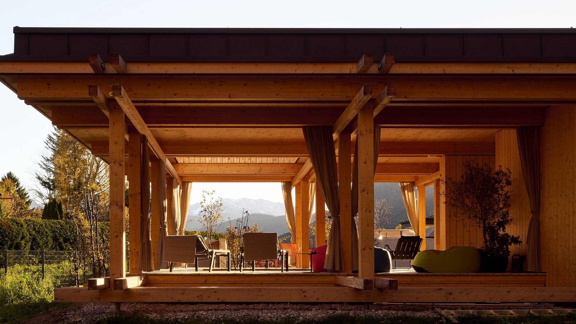 Hotel BERGEBLICK für Wellness in Bad Tölz Moderner Holzpavillon mit Sitzbereich und Bergblick im Hintergrund