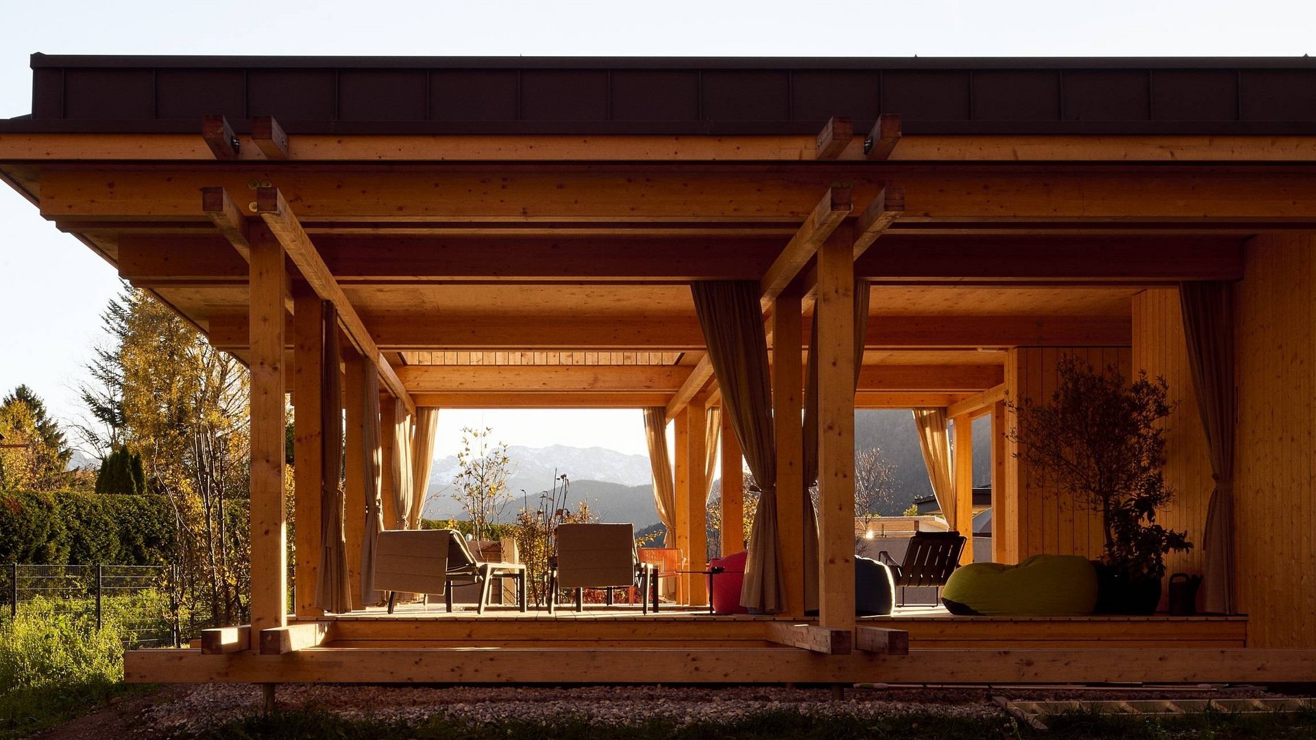 Warum ins BERGEBLICK? Moderner Holzpavillon mit Sitzbereich und Bergblick im Hintergrund