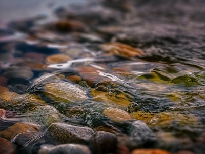 Kurzurlaub in Bayern? Im BERGEBLICK Bunte Steine unter klarem, fließendem Wasser am Flussbett