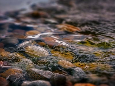 Kurzurlaub in Bayern? Im BERGEBLICK Bunte Steine unter klarem, fließendem Wasser am Flussbett