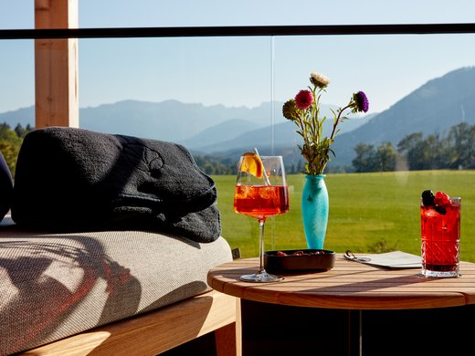 Hotel BERGEBLICK in Bavaria Drinks and flowers on wooden table with mountain view in background