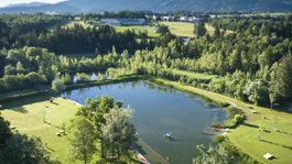 Urlaub in der Natur Bayerns Landschaft mit Teich, Wiese und Bergen im Hintergrund bei klarem Himmel