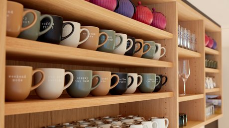 Pictures of a dream holiday in Bad Tölz Various colorful coffee mugs and teapots on wooden shelves