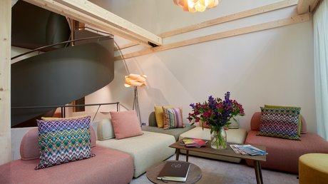 Pictures of a dream holiday in Bad Tölz Modern living room with colorful cushions, wooden ceiling beams, and flower vase on table