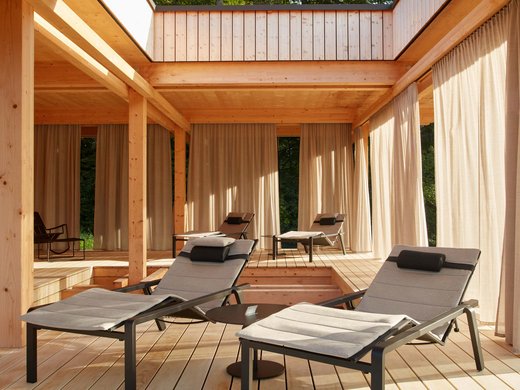 Your retreat at BERGEBLICK. Modern wooden terrace with cushioned loungers and curtains