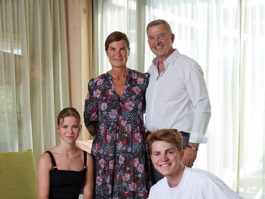 Wellnessurlaub in Bayern Familie mit zwei Erwachsenen, zwei Jugendlichen und einem Hund im Wohnzimmer