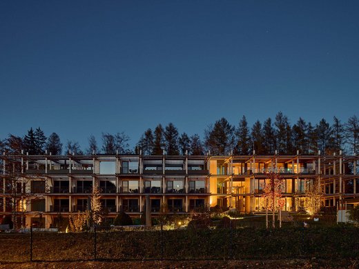 Conferences and seminars in Bad Tölz Modern multi-story building at night with illuminated interiors and trees in the background