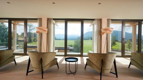 Pictures of a dream holiday in Bad Tölz Modern chairs and lamp with view of green field and mountains through large windows