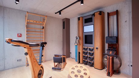 Pictures of a dream holiday in Bad Tölz Modern home gym with wooden exercise bike and fitness equipment in a concrete room