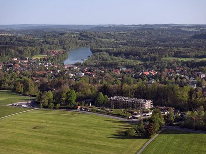Dein Natururlaub in Bayern: BERGEBLICK Luftaufnahme eines grünen Tals mit Fluss, Wald und Gebäuden in einer ländlichen Gegend