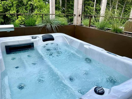 Hotel mit Whirlpool im Zimmer in Bayern Whirlpool mit sprudelndem Wasser auf Terrasse mit Pflanzen im Hintergrund