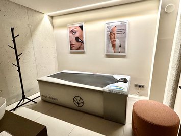 Bad Tölz: Wellness & Beauty Moderner Spa-Raum mit medi stream Spa-Bett und Werbeplakaten an der Wand