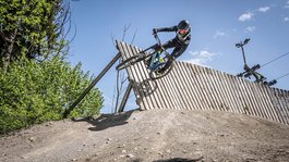 Urlaub in der Natur Bayerns Mountainbiker fährt an einer Holzrampe an sonnigem Tag