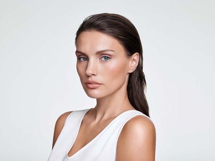 Bad Tölz: wellness & beauty Portrait of a woman with smooth skin and wet brown hair on light background