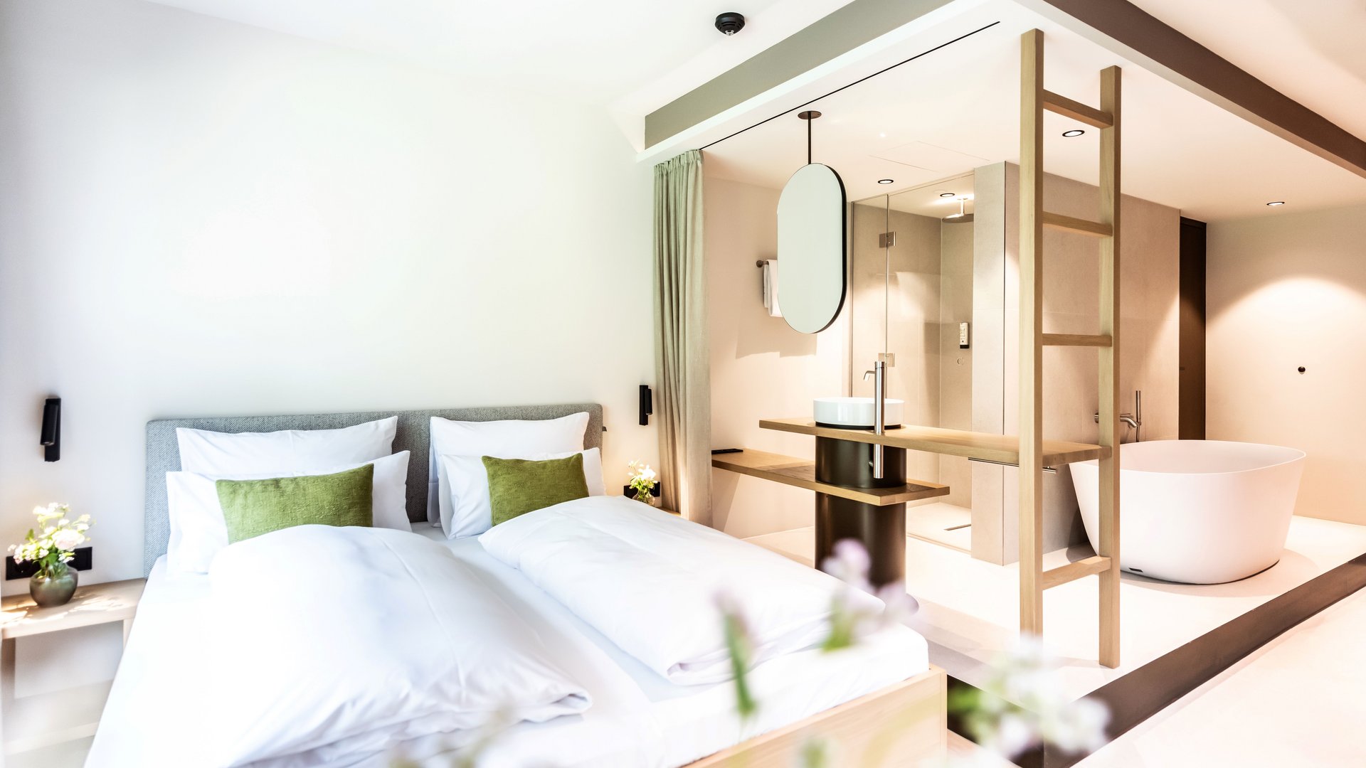 Holiday at BERGEBLICK in Bad Tölz Modern bedroom with double bed and freestanding bathtub in open bathroom