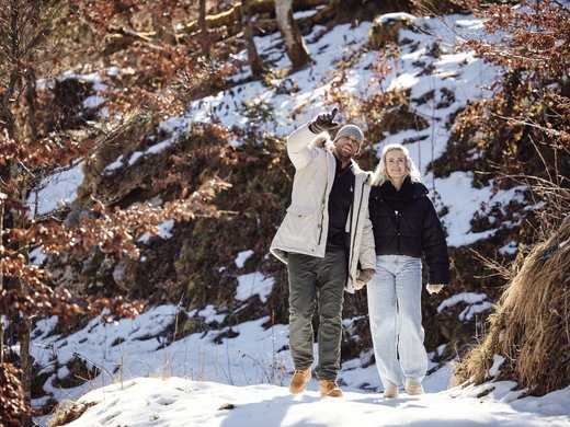 What’s included at BERGEBLICK? Couple hiking in snowy forest, man pointing ahead