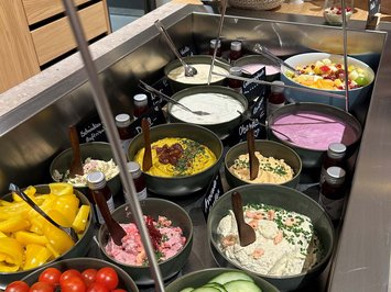 Board and restaurants Counter with fresh vegetables, dips, yogurt, and pastries for breakfast buffet