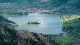 Your active summer holiday in Bavaria View of a mountain lake with an island and surrounding villages in the valley