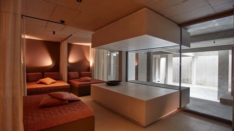Pictures of a dream holiday in Bad Tölz Modern relaxation room with orange sofas and large windows overlooking a bright concrete area