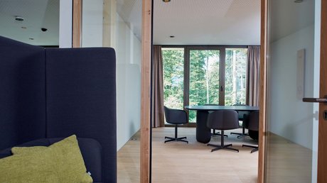Pictures of a dream holiday in Bad Tölz Modern meeting room with glass walls, black chairs, and a view of greenery outside