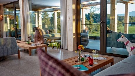 Pictures of a dream holiday in Bad Tölz Cozy living area with wooden furniture and large glass doors opening to terrace and landscape