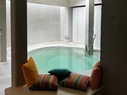 Wellness holiday in Bavaria with mountain view Modern indoor pool with colorful cushions on a bench