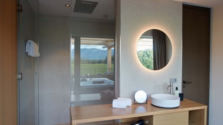 Pictures of a dream holiday in Bad Tölz Modern bathroom with illuminated round mirror and mountain view