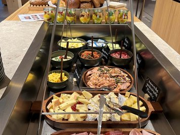 Board and restaurants Buffet with cold cuts, cheese, salmon, spreads, fruits, and assorted bread rolls