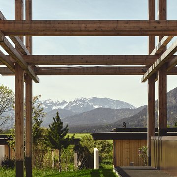 Neues aus Bad Tölz Holzbau mit Blick auf Berge und grüne Landschaft im Hintergrund
