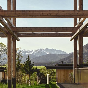 Neues aus Bad Tölz Holzbau mit Blick auf Berge und grüne Landschaft im Hintergrund