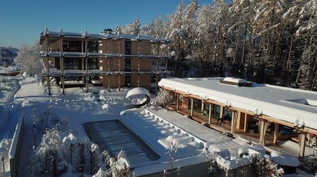 Pictures of a dream holiday in Bad Tölz Snow-covered modern building with pool and forest in the background under clear blue sky