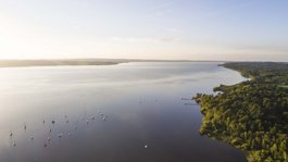 Your active summer holiday in Bavaria Aerial view of a lake with sailboats and forested shore in sunlight