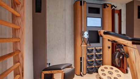 Pictures of a dream holiday in Bad Tölz Modern gym room with wooden exercise machines and rowing machine by concrete wall