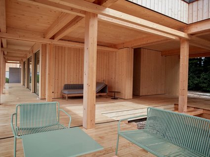 Dein Natururlaub in Bayern: BERGEBLICK Moderner Holzpavillon mit grünen Metallstühlen und Tisch im Freien