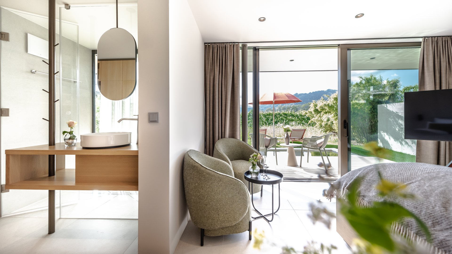 Gartensuite in Bayern mit BERGEBLICK Helles Hotelzimmer mit Sitzecke und Terrasse mit Gartenblick