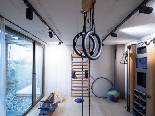 Wissenswertes aus Bad Tölz Moderner Fitnessraum mit Turnringen, Rudergerät und verschiedenen Trainingsgeräten