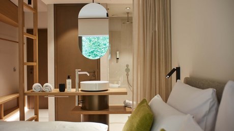 Pictures of a dream holiday in Bad Tölz Modern hotel room with bed, washbasin, and oval mirror