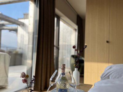 Dein romantisches Hotel in Bayern mit BERGEBLICK Flasche Prosecco mit zwei Gläsern und Blumen in einer modernen Wohnung