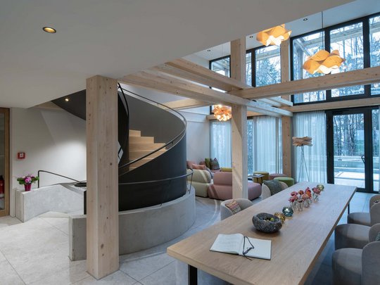 Wissenswertes aus Bad Tölz Modernes Wohnzimmer mit Wendeltreppe und großem Holztisch mit Dekoration