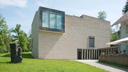 Urlaub in der Natur Bayerns Modernes Gebäude mit großem Glasfenster und Terrasse mit Menschen