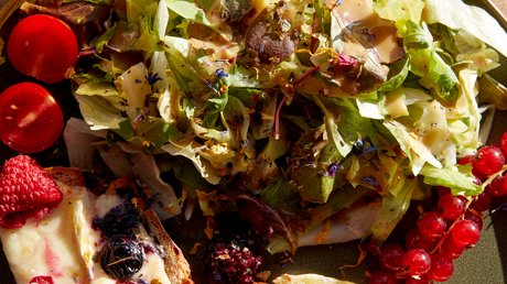 Pictures of a dream holiday in Bad Tölz Salad with cheese bread and berries on a plate, next to a glass of beer