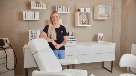Pictures of a dream holiday in Bad Tölz Woman smiling in a modern cosmetic clinic with white furniture and products